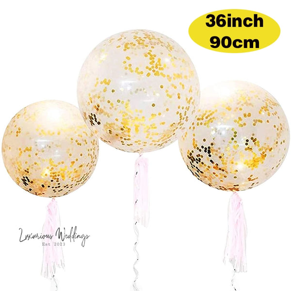 three white balloons with gold confetti on them