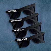 a set of four pairs of sunglasses with the names of grooms and best man