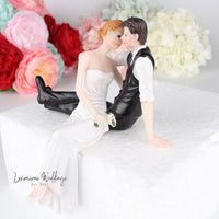 a bride and groom figurine sitting on a cake