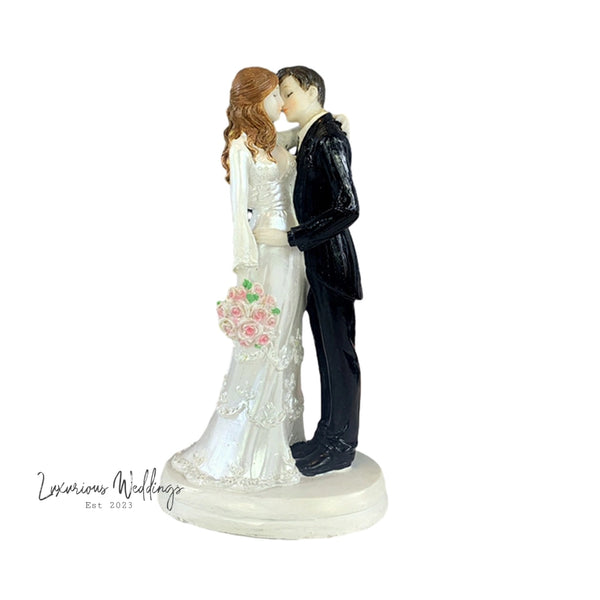 a figurine of a bride and groom kissing