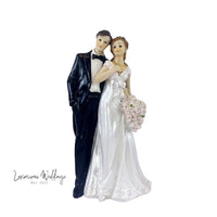 a wedding cake topper of a bride and groom