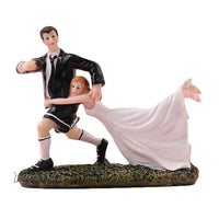 a figurine of a bride and groom on a rock