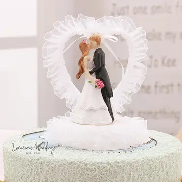 a bride and groom figurine on top of a cake