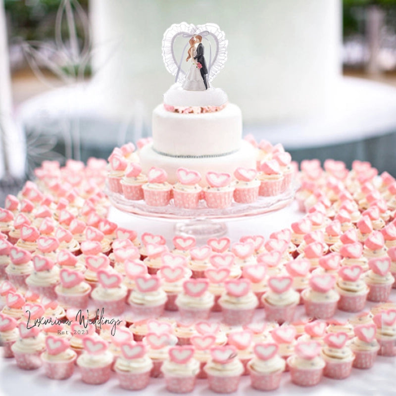 a wedding cake and cupcakes on a table