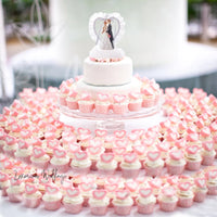a wedding cake and cupcakes on a table
