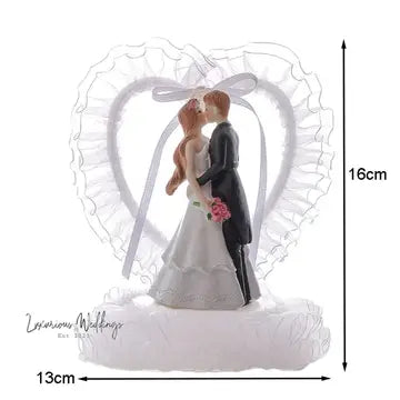 a wedding cake topper with a bride and groom kissing