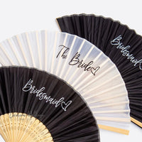 three black and white fans with the bride and groom written on them