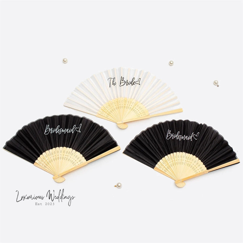 three black and white fans with the names of bride and groom