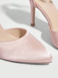 a pair of pink high heeled shoes on a white surface