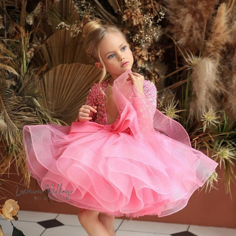 a little girl in a pink dress posing for a picture