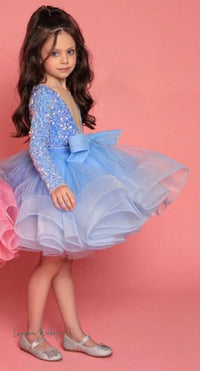 a little girl wearing a blue and pink dress