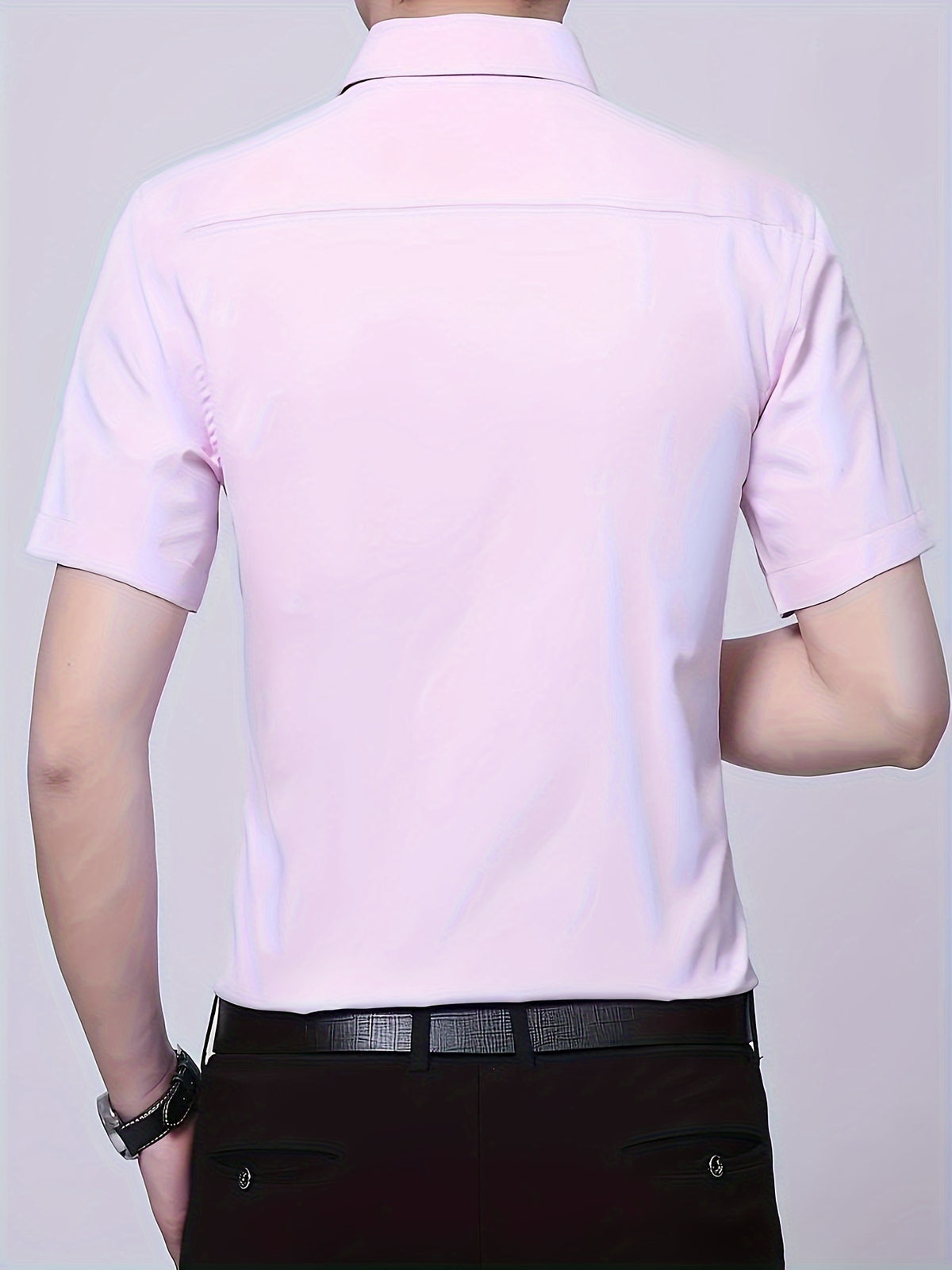 a man wearing a pink shirt and black pants