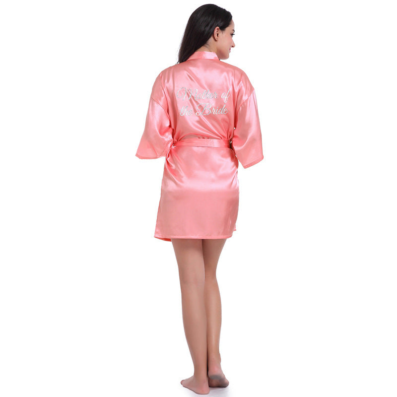 a woman in a pink robe standing in front of a white background