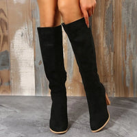 Stylish black point toe block heel boots made of suede, perfect for adding elegance to any outfit.