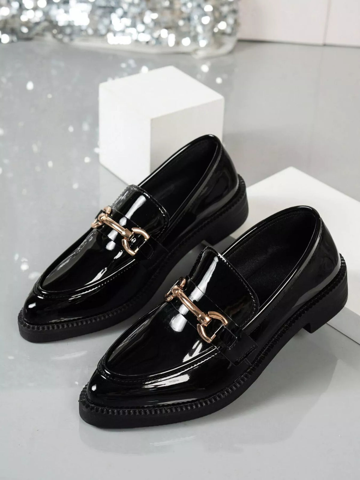 Point toe block heel loafers in shiny black PU leather with gold chain detail, stylish footwear option for any occasion.