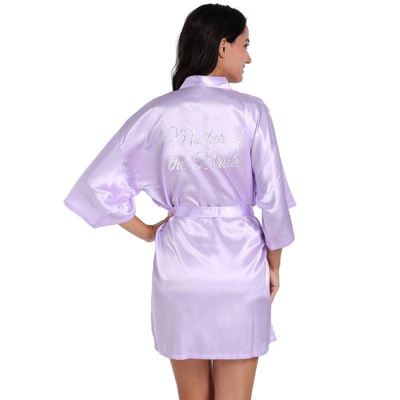 a woman wearing a purple robe with the words, mother of the bride on it
