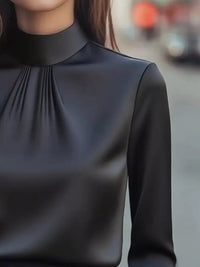 Mock Neck Long Sleeve Blouse with Pleated Detail in black color, featuring subtle pleats and a sleek design.