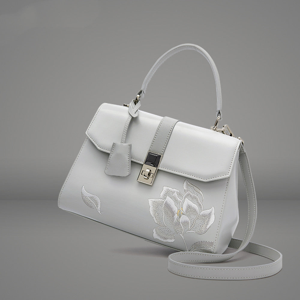 a white purse with a flower on it