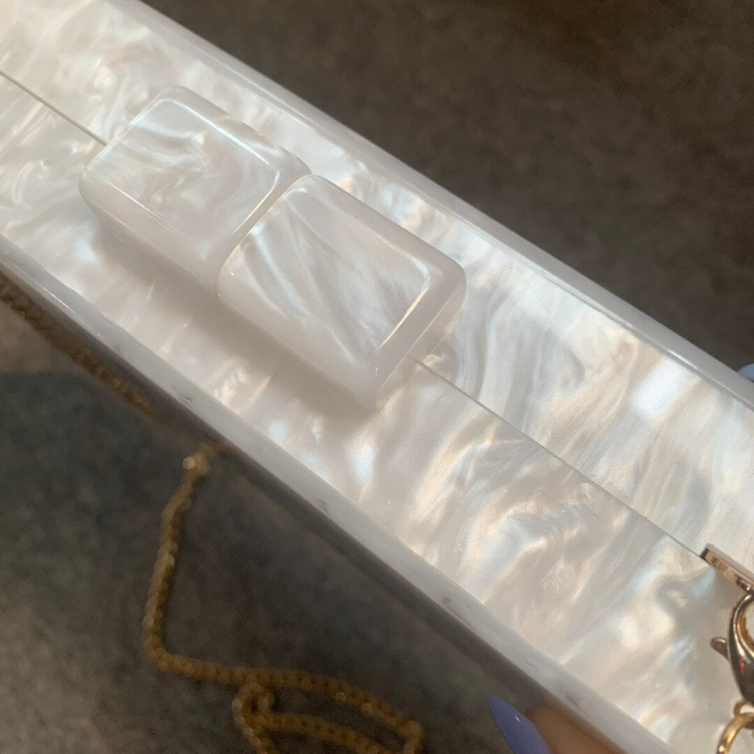 Close-up of Mrs Letter evening bag in white marble with glossy acrylic finish, perfect for luxurious weddings.