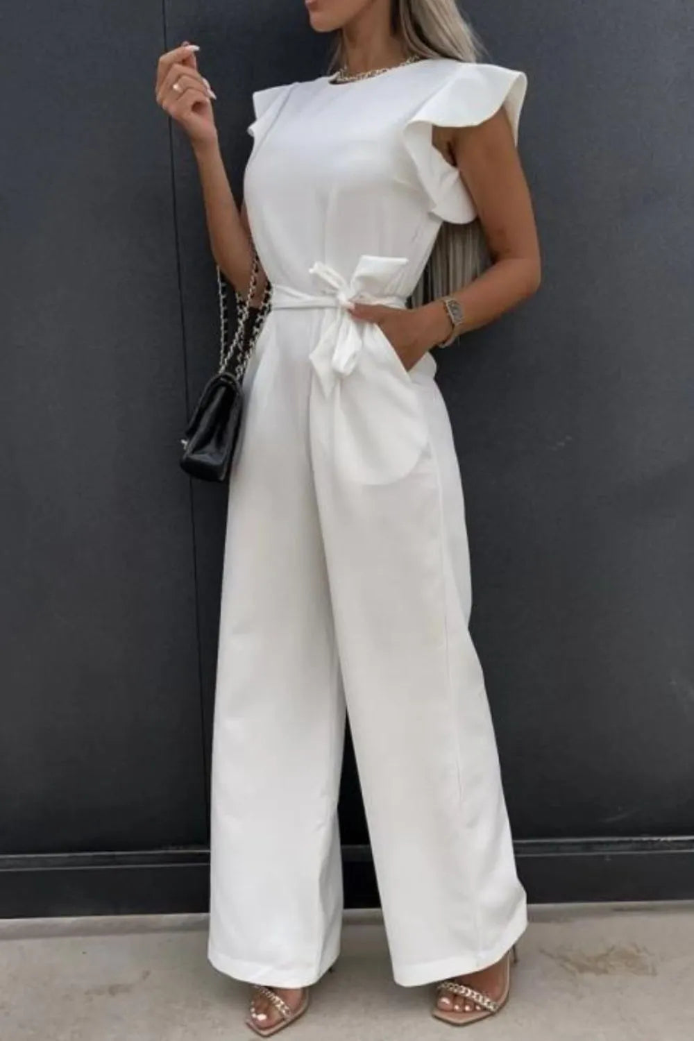 Stylish round neck cap sleeve jumpsuit in white with tied waist and wide legs, perfect for casual or dressy occasions.
