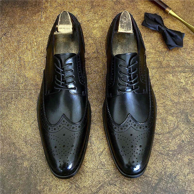 Black genuine leather brogue business shoes with elegant detailing for luxurious weddings and professional events.