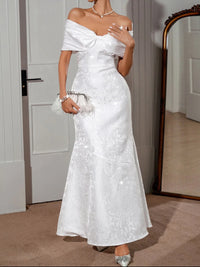 Elegant off-shoulder maxi dress in white with lace-up design and flowing silhouette, ideal for special occasions.