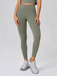 High waist active leggings in green with pockets, featuring a fitted design and paired with athletic shoes.
