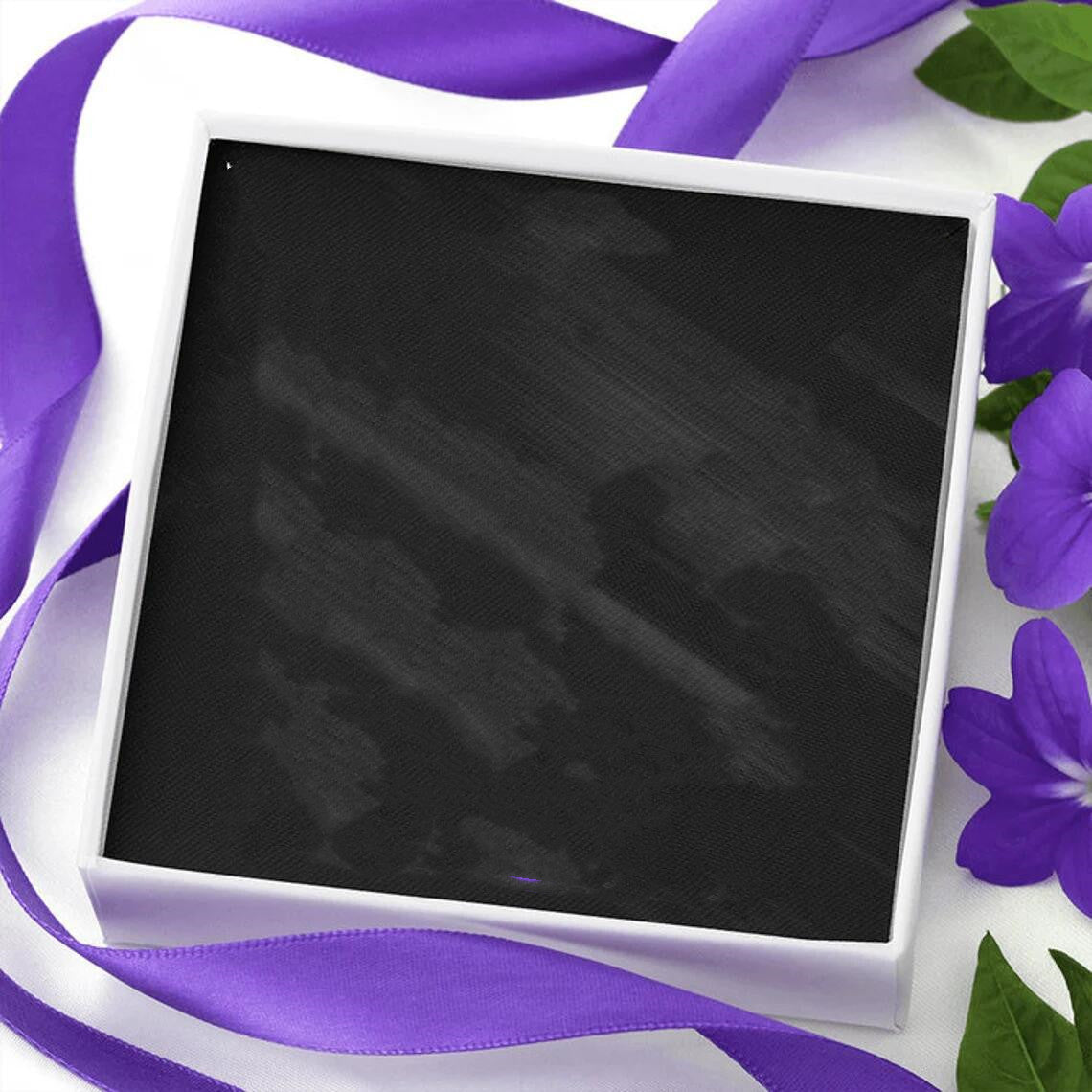 a white box with a purple ribbon around it