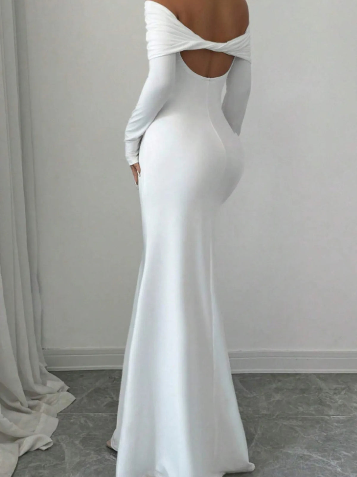 Back view of an off-shoulder long sleeve bodycon maxi dress in white, perfect for luxurious weddings.