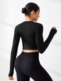 Woman wearing a black round neck long sleeve active t-shirt styled with high-waisted leggings.