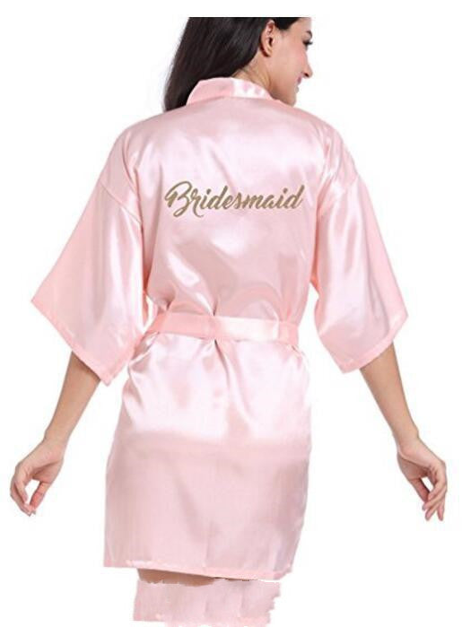 a woman in a pink robe with the word bridesmaid on it