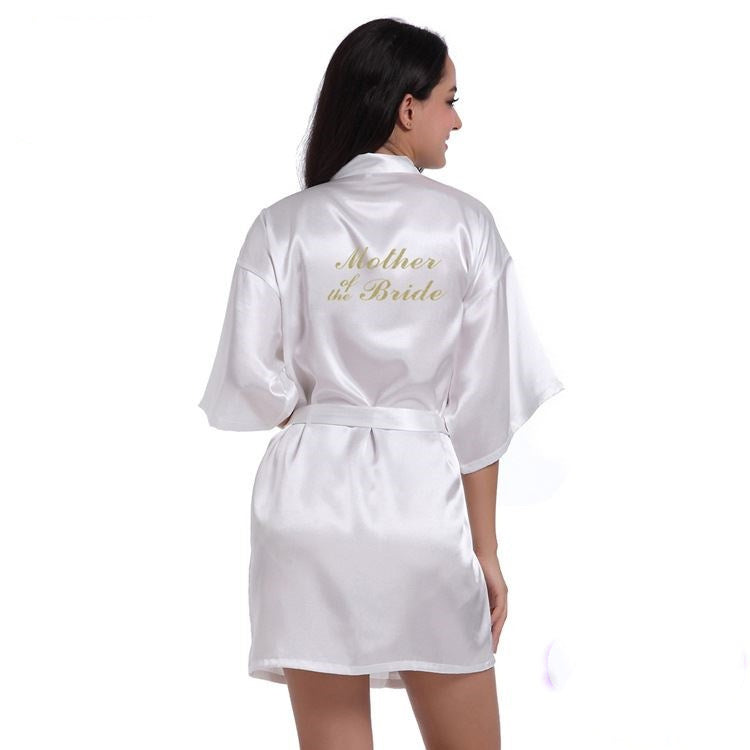 a woman wearing a white robe with gold lettering