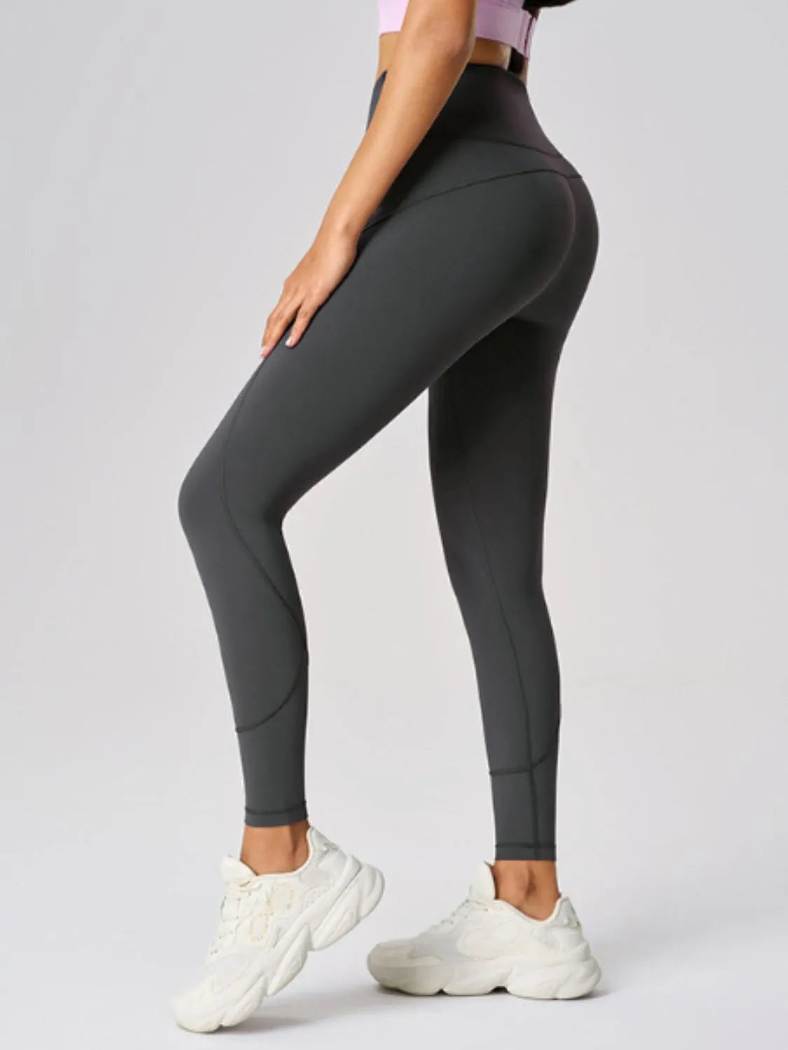 High waist active leggings in dark gray showcased on a model, paired with white sneakers, perfect for workouts.
