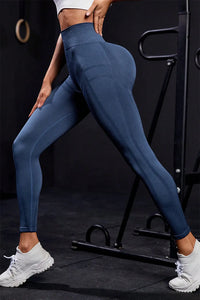 Wide waistband high waist active leggings in dark blue displayed in a workout environment, showcasing highly stretchy material.