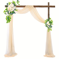 a wooden cross decorated with flowers and greenery