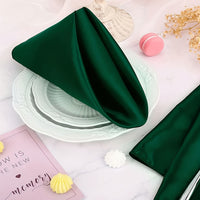 a table topped with plates and napkins covered in green satin