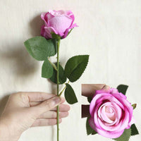 a person holding a pink rose in their hand