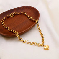 Heart Pendant Toggle Clasp Chain Necklace displayed on a wooden plate, featuring a gold-plated design.