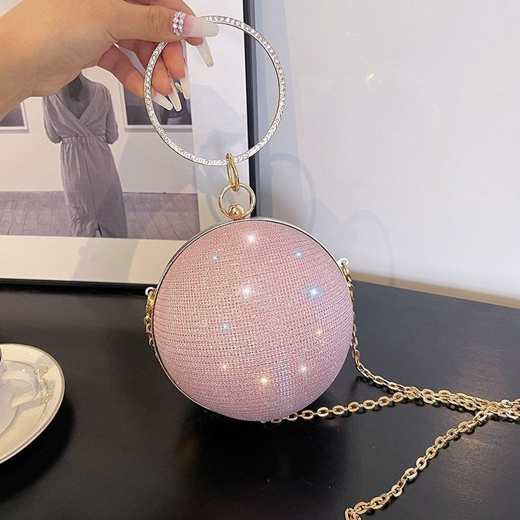 Luxurious pink spherical handbag with ring handle, perfect for elegant weddings and stylish occasions.