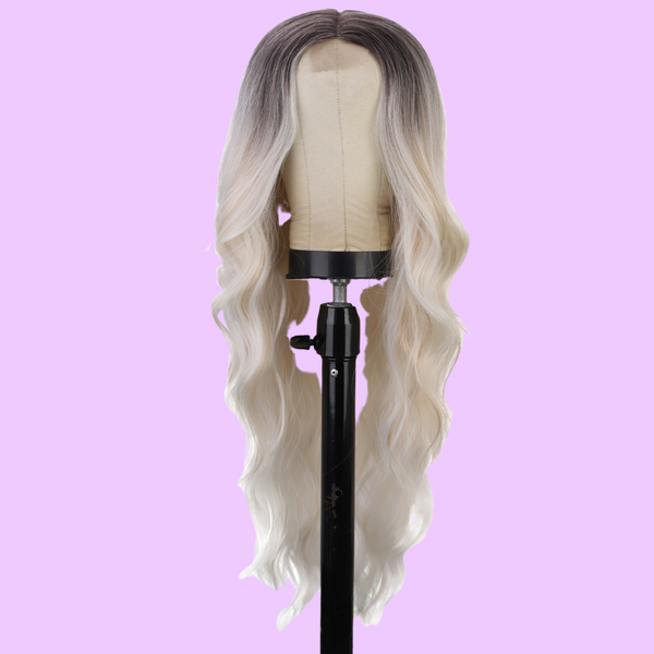 a wig on a stand on a pink background