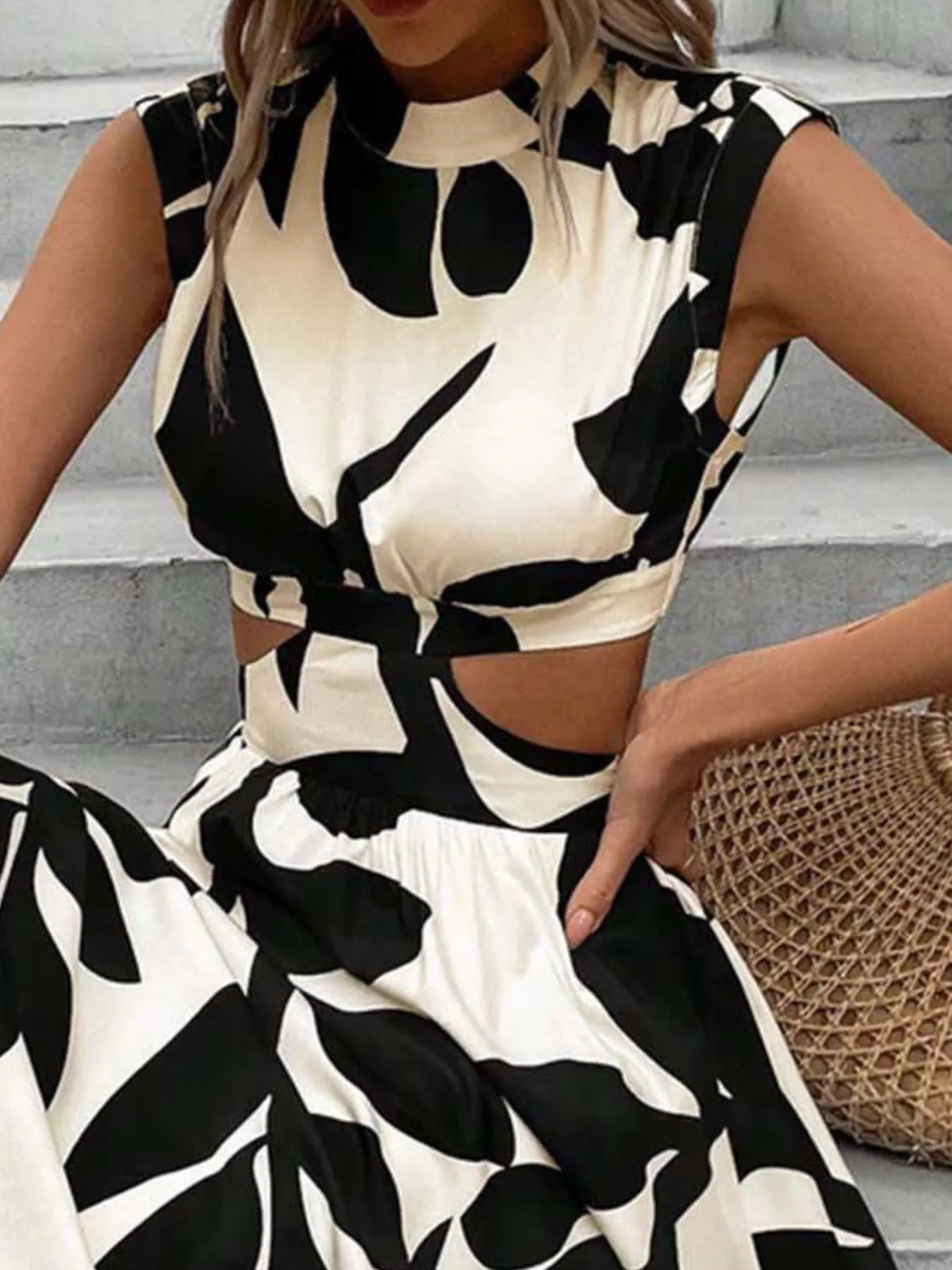 Cutout printed sleeveless dress with bold black and white floral pattern, perfect for summer fashion.