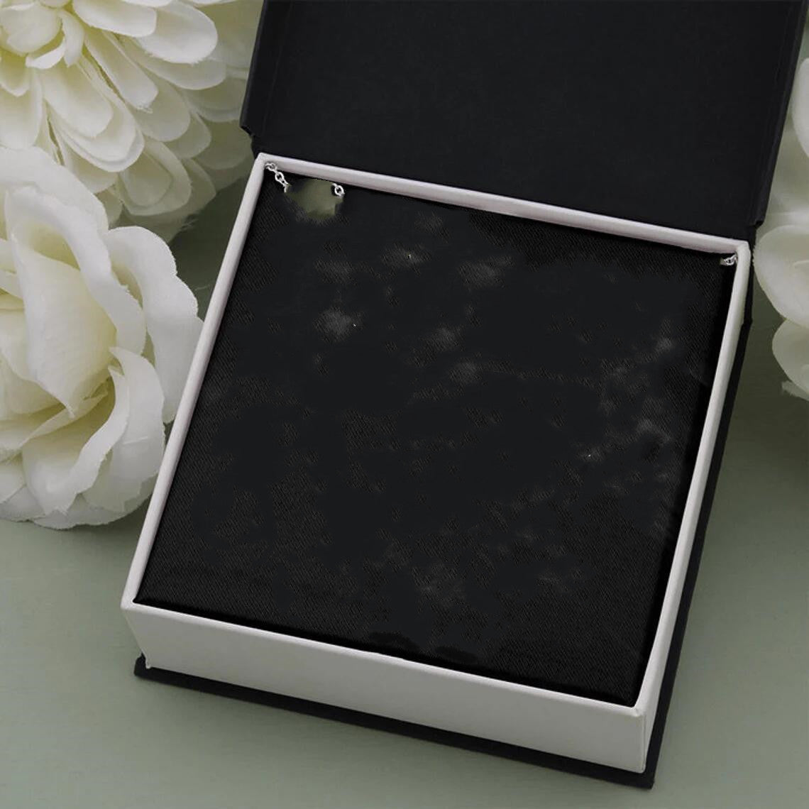 a white flower and a black box on a table