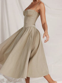 Ruched sweetheart neck cami dress in beige with flowing skirt, showcasing sporty elegance and comfort.