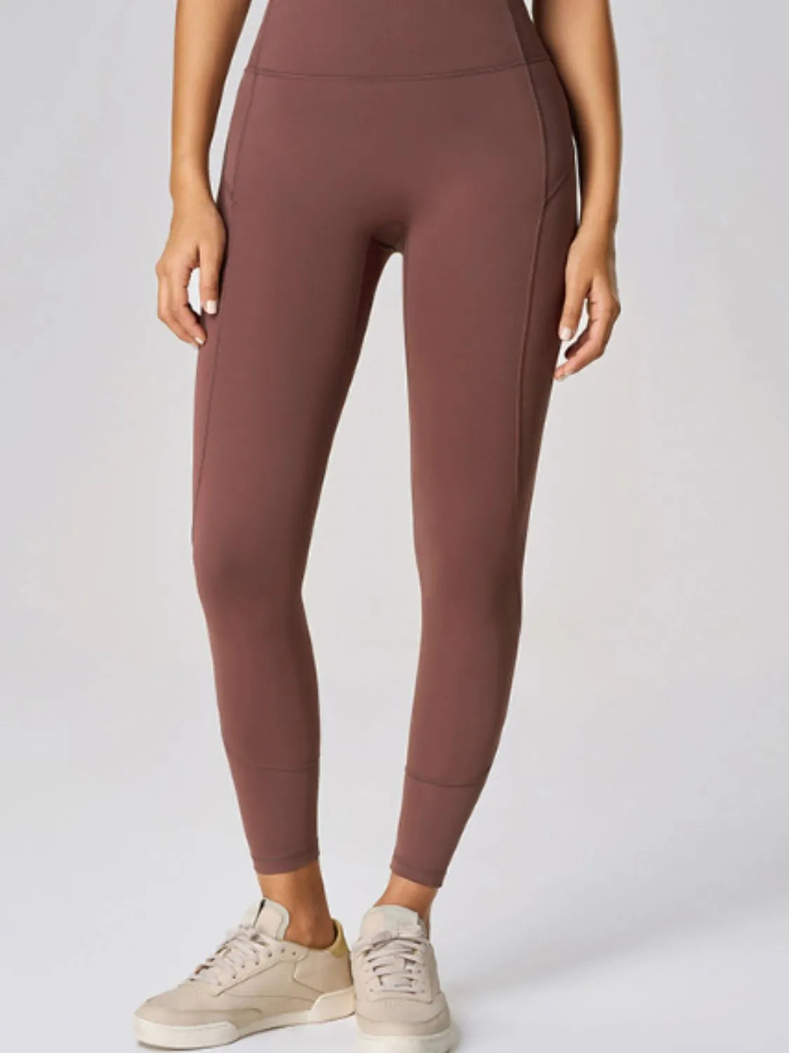 High waist active leggings in a brown shade, featuring a pocketed design and made with stretch fabric.