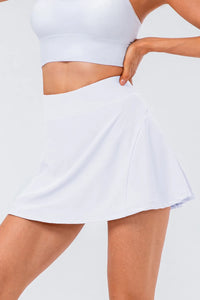High waist pleated active skirt displayed in white, showcasing its stretchy material and stylish fit.