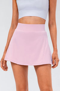 High waist pleated active skirt in soft pink, highlighting stretchy fabric and flattering A-line cut.