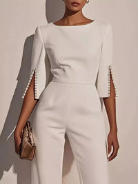 Wide-Leg Jumpsuit with Slit Sleeve featuring pearl details on the sleeves and a sleek, modern design.