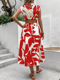 Back view of a woman in a sleeveless red and white floral cutout dress, showcasing the tied waist and skirt details.