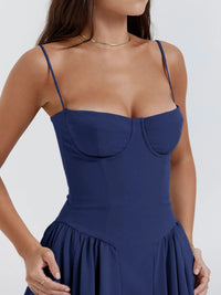 Model wearing a navy ruched sweetheart neck cami dress showcasing a fitted bodice and flared skirt.