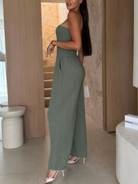 Model showcasing a smocked tube wide-leg jumpsuit in olive green, ideal for formal wear and accessories in NZ.